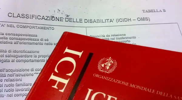 Classificazione delle disabilità (ICIDH - OMS) e copertina rossa del manuale ICF.