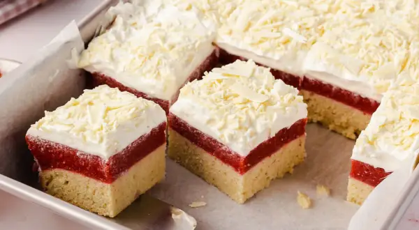 Schichtkuchen mit roter Fruchtschicht, weißer Creme und Schokostreuseln, wie von Frau Holle gebacken.