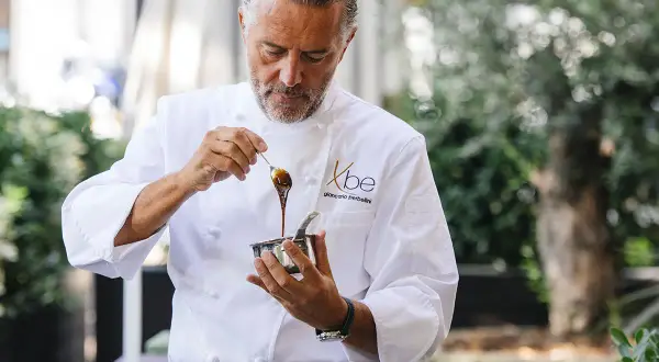 Chef Giancarlo Perbellini, con la sua maestria, prepara un ingrediente per le sue nuove stelle Michelin.