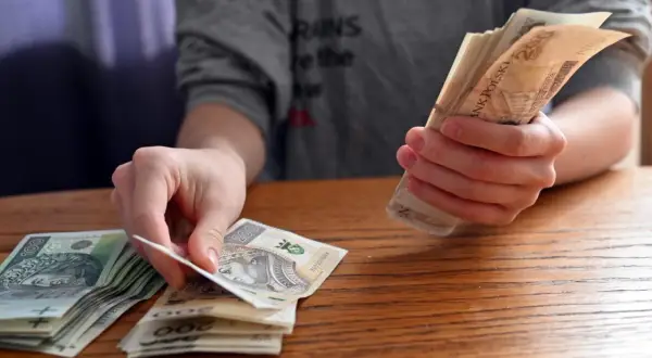 Dłonie liczą polskie banknoty. Zastanawiasz się, jakie dane o użytkownikach zbierają aplikacje pożyczkowe pod pretekstem loterii?