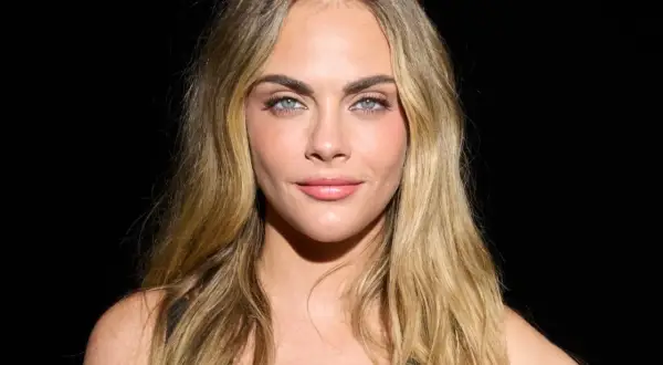 Cara Delevingne mit blondem, leicht plattem Haar und blauen Augen.