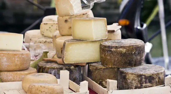 Un étalage de fromages variés, dont un beau fromage parisien, empilés et prêts à être dégustés.