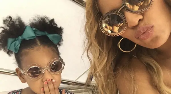 Mała córka Beyoncé w okularach w kształcie kwiatków i zielonej kokardce, obok mamy w okularach z ozdobnymi oprawkami.