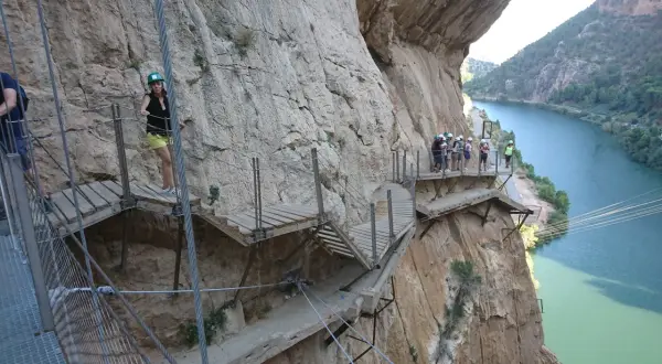 Wagemutige Wanderer auf dem Caminito del Rey bei Malaga, ein Pfad an steilen Felswänden über einem Fluss.