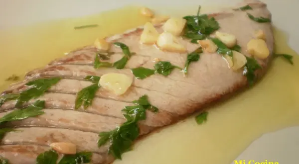 Deliciosa ventresca a la plancha con ajo laminado y perejil fresco, nadando en un sabroso aceite.