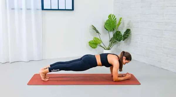 Donna in posizione di plank, esercizio che rafforza il **core significato** di stabilità e forza.