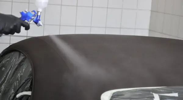 Profesjonalne czyszczenie dachu cabrio. Rękawica i pistolet natryskowy w akcji, odświeżanie materiału.