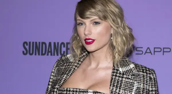 Taylor Swift w stylizacji w kratę, z mocnym makijażem, na tle napisu Sundance. Tekst "august" idealnie pasuje do jej nastroju.