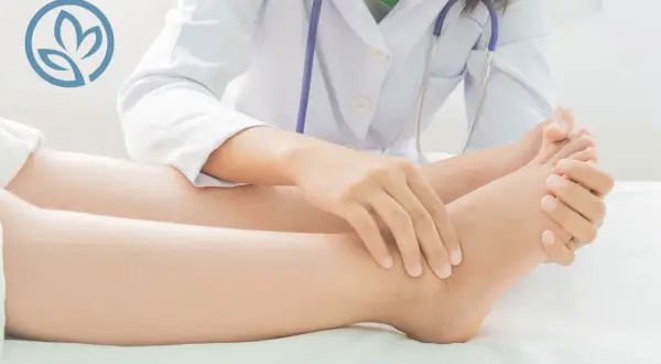 Medico esamina caviglia per valutare dolore.
