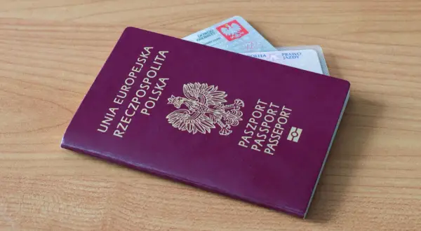 Polski paszport i dowód osobisty leżą na drewnianym stole. Czy na Wyspy Kanaryjskie potrzebny jest paszport? Tak, jeśli nie podróżujesz na dowód.