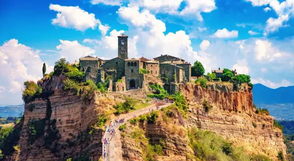 Antico centro storico su una rupe, con un ponte pedonale che conduce al borgo.