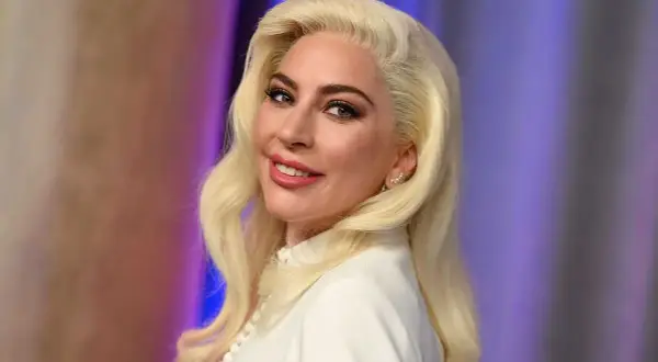 Lady Gaga med blont hår och vit klänning, ser ut som en stjärna som kan ha barn.