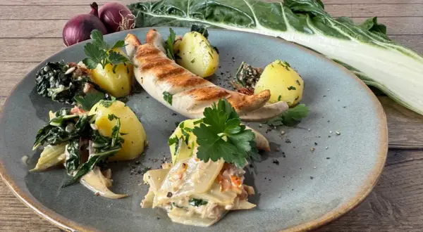 Gegrillte Wurst mit Salzkartoffeln und cremigem Gemüse. Ein Gericht, das zeigt, was gut zu Mangold passt.