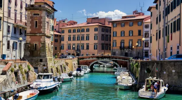 Canaux de Livourne, bateaux amarrés, bâtiments colorés et un pont. Idéal pour savoir que faire à Livourne.