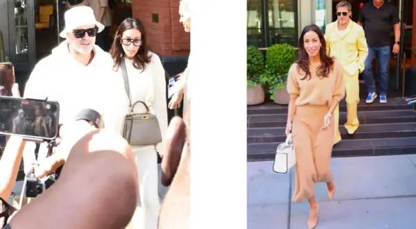 Inés de Ramón, con un conjunto beige, camina sonriente mientras Brad Pitt, con un llamativo traje amarillo, desciende escaleras.