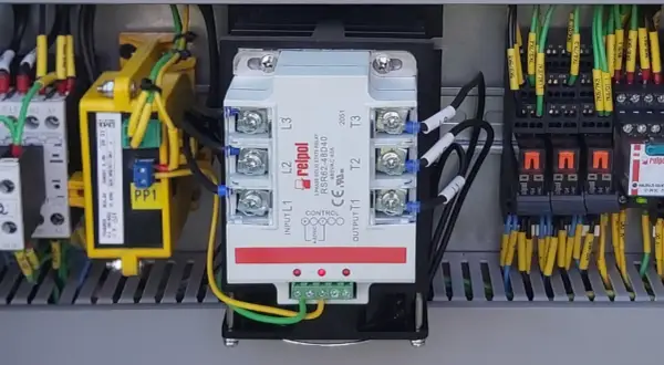Wewnątrz szafy sterowniczej widoczny jest trójfazowy przekaźnik SSR marki Relpol, otoczony przewodami i innymi elementami elektrycznymi.