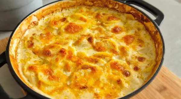 Ein goldbraun überbackenes Kartoffelgratin im schwarzen Gusseisen-Auflauf, perfekt für ein gemütliches Kartoffelgratin Rezept.