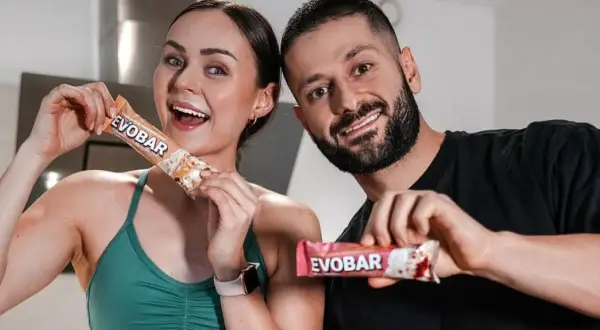 Ein glückliches Paar hält proteinriegel vor dem sport. Sie sind bereit für ihr Training mit EVOBAR.