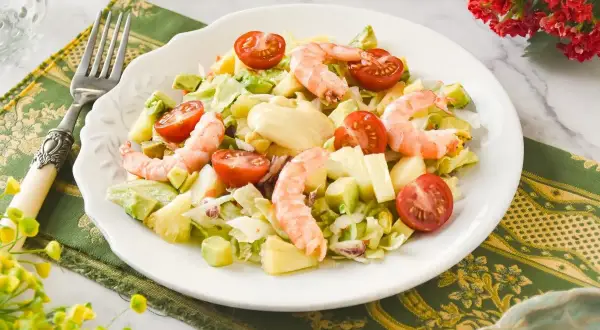 Ensalada tropical con camarones, aguacate, piña y tomates cherry. Un festín de sabores frescos y vibrantes.
