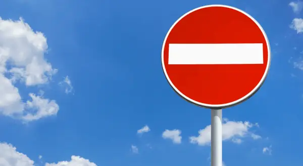 Panneau sens interdit rouge et blanc sous un ciel bleu avec des nuages. Combien de points pour un sens interdit ? Zéro, c'est une interdiction !