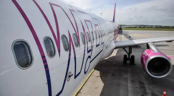 Samolot Wizz Air na płycie lotniska. Szukaj promocje wizzair i leć w podróż!