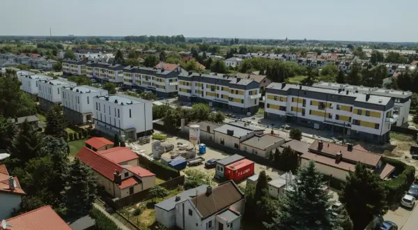 Nowe bloki mieszkalne w budowie, otoczone starszą zabudową i zielenią. To obraz rozwoju tej największej dzielnicy Warszawy.