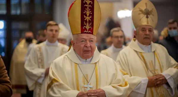 Trzech duchownych w szatach liturgicznych, jeden w mitrze z ozdobami.