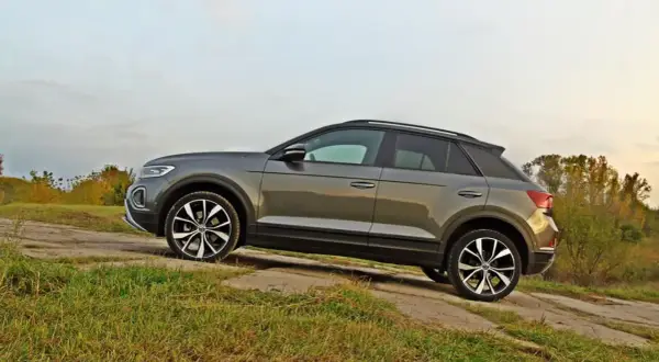 Szary VW T-Roc na tle jesiennego krajobrazu. Poznaj jego wymiary i możliwości terenowe.