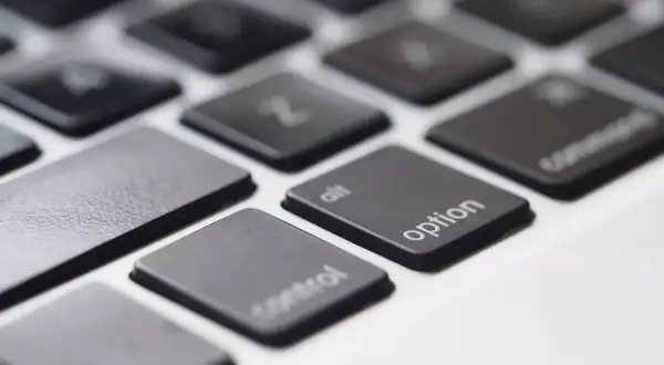 Zbliżenie na klawiaturę laptopa, widoczne klawisze "control", "alt", "option" i "command". Klawisz spacji jest pusty.