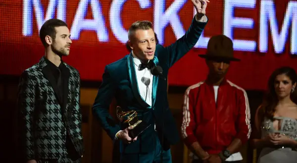 Macklemore odbiera nagrodę Grammy: najlepszy debiutujący artysta. Obok niego stoją Lewis Hamilton, Pharrell Williams i Anna Kendrick.