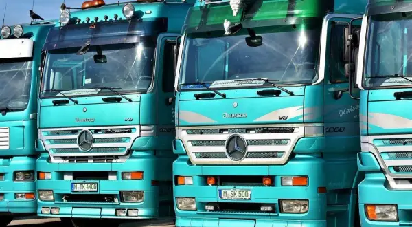 Varios camiones Mercedes-Benz Actros turquesas en fila. ¿Cuántos litros de aceite lleva un camión? Depende del modelo, pero estos gigantes pueden necesitar entre 20 y 40 litros.