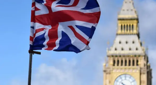 Flaga Wielkiej Brytanii powiewa przed Big Benem. Marzenie o podróży i uzyskaniu wizy do Londynu staje się realne.