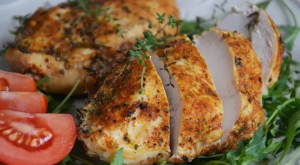 Soczysty filet z kurczaka z piekarnika, przyprawiony ziołami, podany z pomidorami i rukolą.