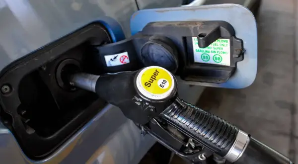 Zapfsäule mit E10-Kennzeichnung wird in einen Tankstutzen eingeführt.