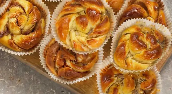 Nybakade bullar med mandelmassa och vallmofrön, gyllene och glansiga i sina pappersformar.
