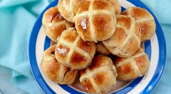 Ein Teller voller goldbrauner Hot Cross Buns, bereit zum Genießen.