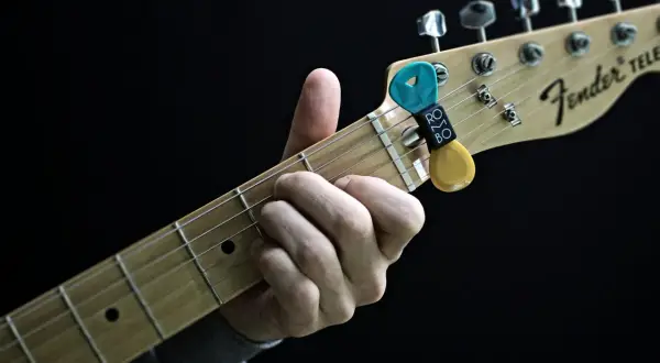 Dłoń grająca akord C na gitarze Fender Telecaster. Kostki z uchwytem na gryfie.