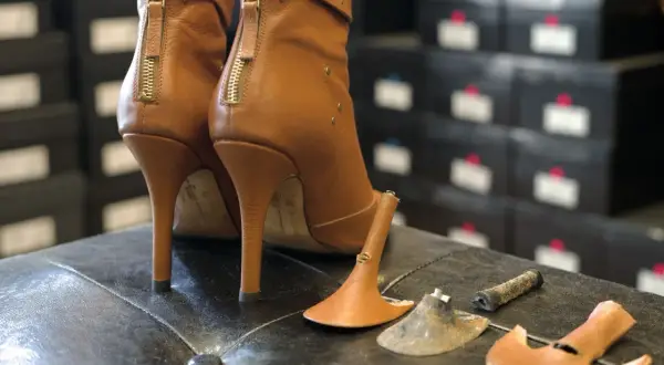 Bottes à talons aiguilles marron avec talons cassés, prêtes à réparer chaussures.