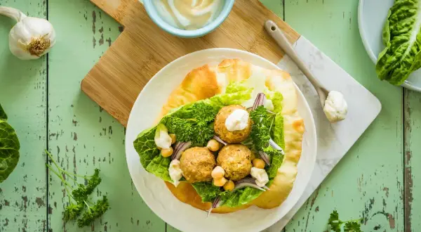 Jak przygotować sos tahini do sałatek i falafeli? Proporcje wody są kluczowe dla idealnej konsystencji. Falafel w picie z sałatą, ciecierzycą i sosem.