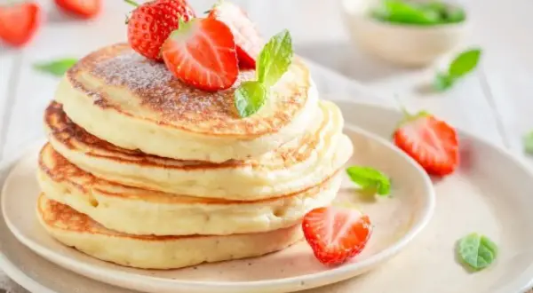 Puszyste pancakes z truskawkami i miętą, idealne na śniadanie. Prosty przepis na pyszne placki.