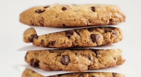 Stapel von vier saftigen Chocolate Chip Cookies, perfekt für Ihr nächstes Rezept.