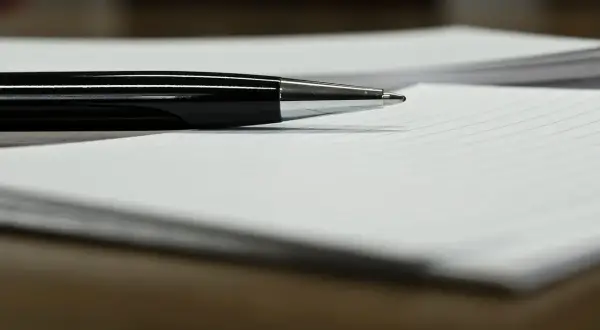Czarny długopis na papierze w linie, gotowy do podpisania ważnego upoważnienia.