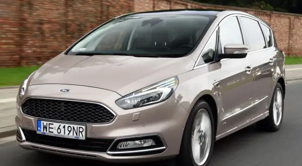 Beżowy Ford S-Max w ruchu. Wiele osób szuka ford s max opinie, ten model wygląda na komfortowy i przestronny.