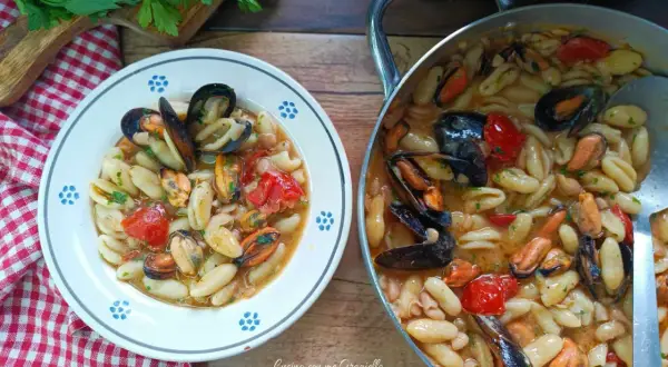 Un piatto invitante di cavatelli cozze e fagioli, con pomodorini e prezzemolo fresco. Un sapore di mare e terra.