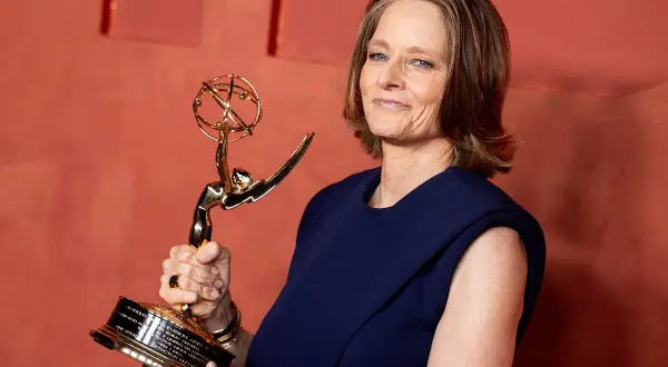 Jodie Foster z dumą trzyma swoją nagrodę Emmy, błyszczącą statuetkę symbolizującą jej wybitne osiągnięcia w telewizji.
