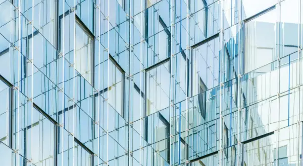 Nowoczesna fasada budynku z tafli szkła, przypominająca wytrzymałość **gorilla glass**.