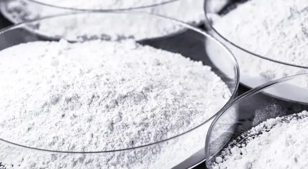 Polveri bianche in capsule di vetro. Il calcio carbonato a cosa serve? È un ingrediente comune in molti prodotti, dall'edilizia alla farmaceutica.