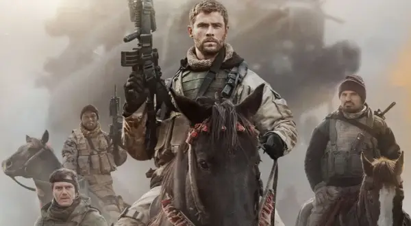 Chris Hemsworth leder en grupp soldater till häst i en actionfylld scen, typiskt för filmer med Chris Hemsworth.