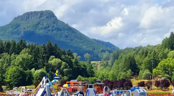 Kolorowy park wodny na **zalewie radkowskim** z górami w tle.
