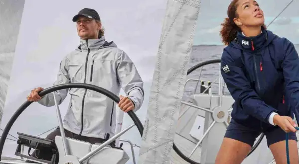 Uomo e donna con abbigliamento tecnico per barca a vela, pronti per navigare.